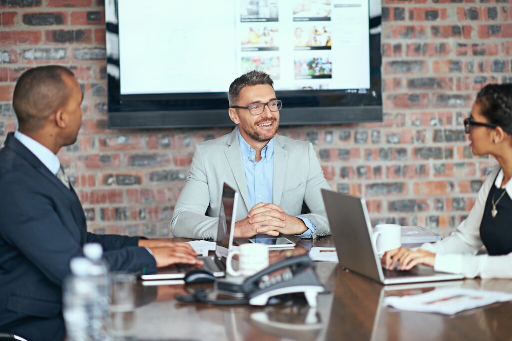 Group of businesspeople meeting in a board room discussing retirement planning.