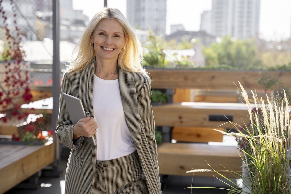 Smiling businesswoman walking on an outdoor patio.