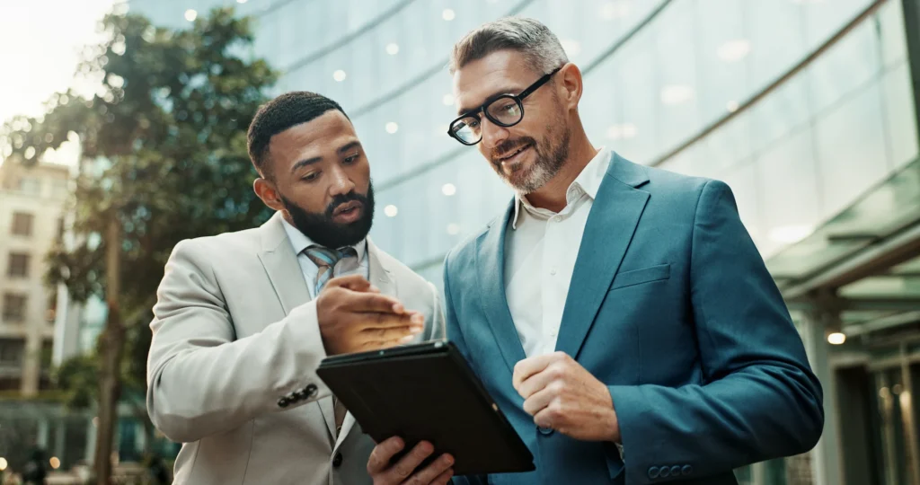 High-net-worth investors reviewing a portfolio on a tablet.
